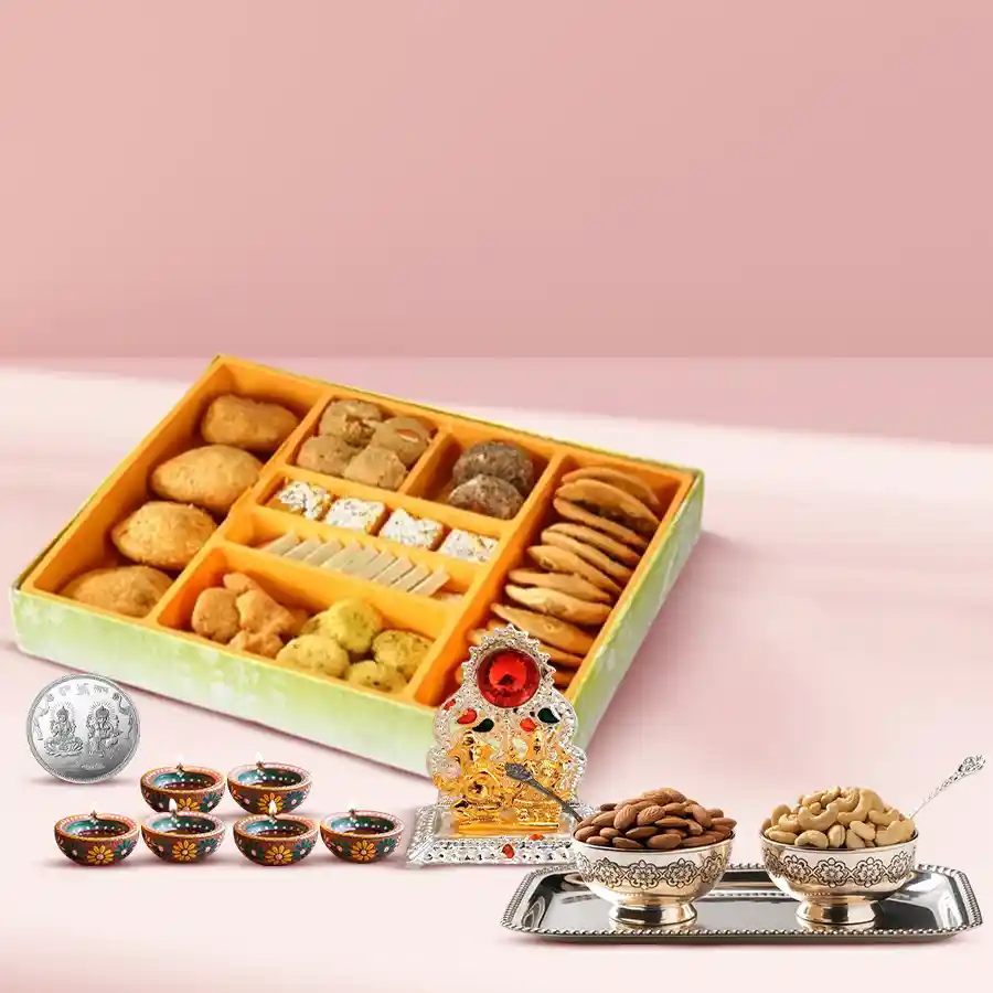 Mouth watering Diwali sweets with dry fruits, antique Ganesh and Laxmi mandap, silver-plated bowls, silver coin, and decorative diyas on display