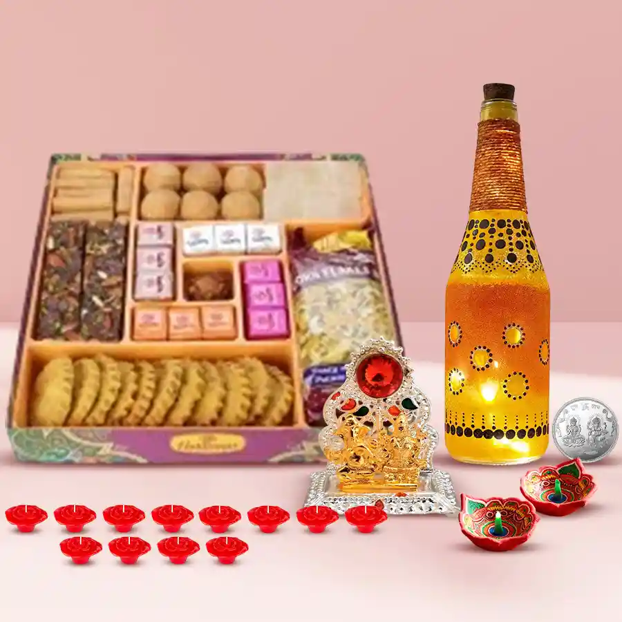 Exclusive Diwali gift set featuring Ganesh Laxmi mandap, colorful diyas, LED lamps, wax candles, premium sweets, savory snacks, and a prosperity coin.