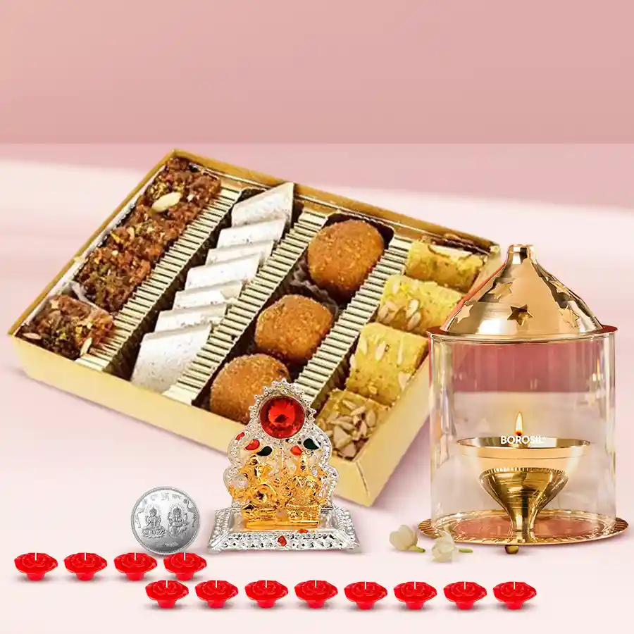 Exclusive Diwali sweets assortment featuring Kaju Barfi, Anjeer Barfi, Besan Laddoo, Soan Papri, Laxmi Ganesh Mandap, Borosil Akhand Diya, decorative candles, and a silver-plated Laxmi Ganesh coin.