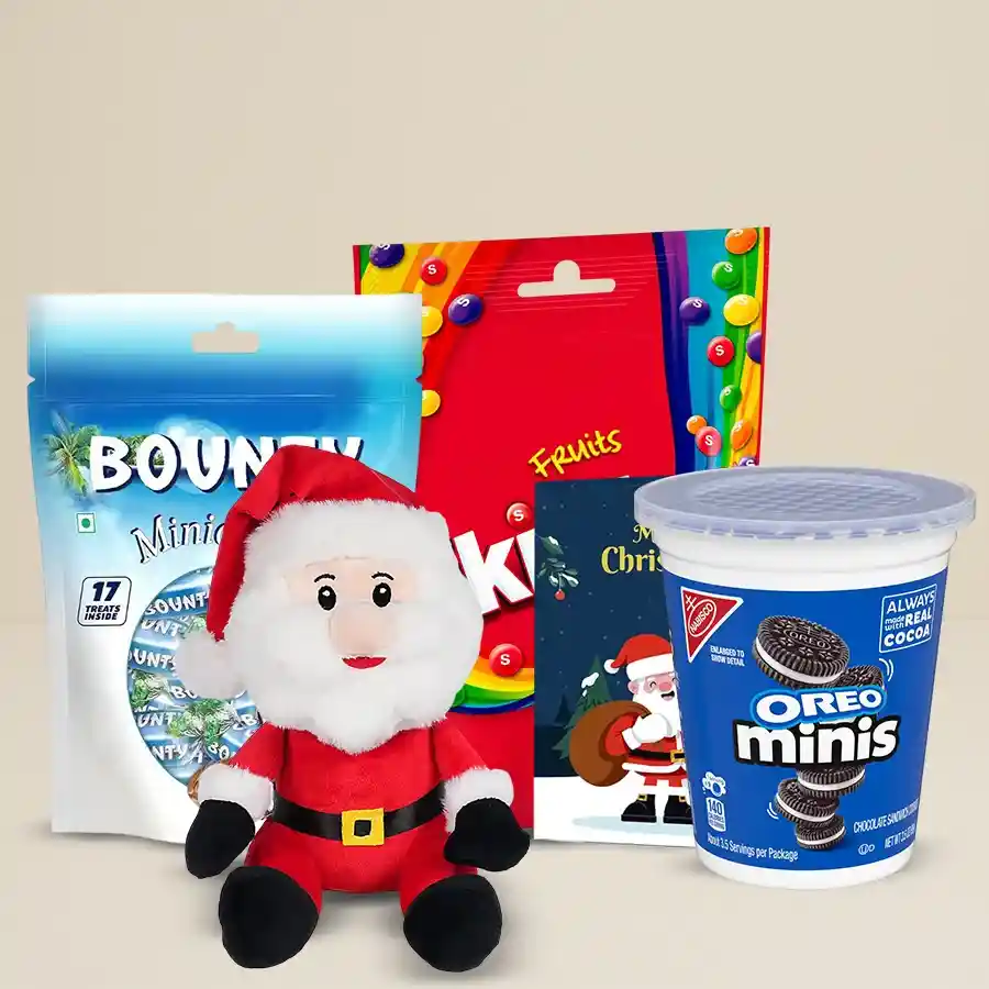 A festive gift set featuring a Santa soft toy, assorted chocolates including Bounty Miniatures, Skittles Fruits, and Cadbury Mini Oreos, along with a Christmas greeting card.