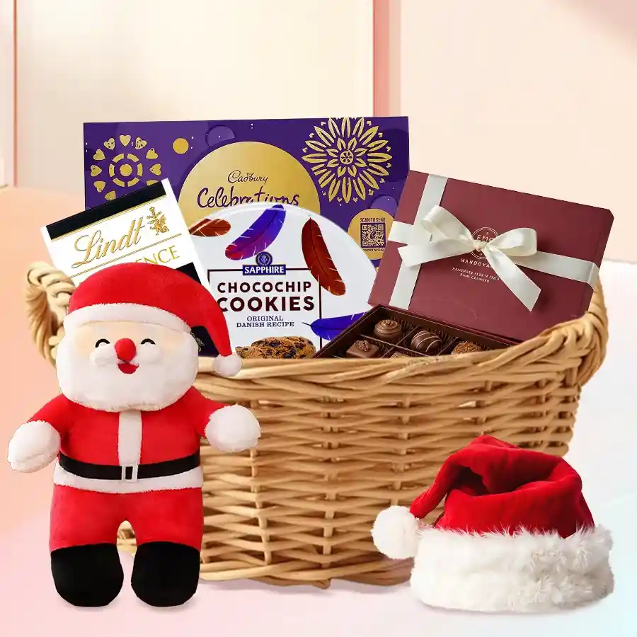 Exquisite Chocos n Assortments Gift Hamper featuring Lindt and Cadbury chocolates, homemade chocolates, Sapphire cookies, a Santa Claus soft toy, and a festive red cap arranged in a cane basket.