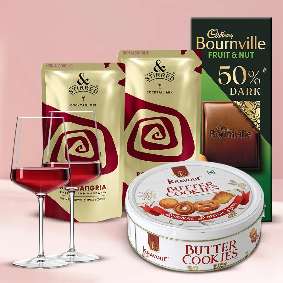 Delicious N Stirred Red Sangria Cocktail set featuring two non-alcoholic sangria mixes, two elegant wine glasses, buttery Kravour cookies, and Cadbury Bournville Fruit n Nut chocolate.