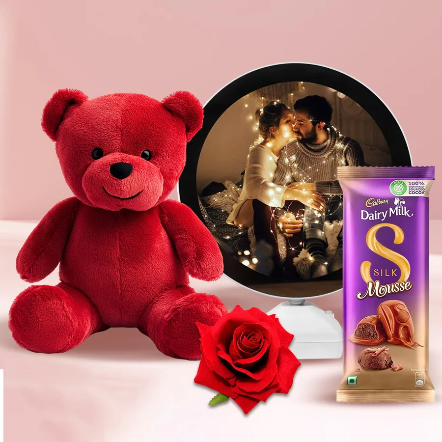 Impressive Be My Valentine Gift Hamper featuring a personalized photo round mirror, Cadbury Silk Mousse Chocolate Bar, red teddy bear, and red velvet rose.