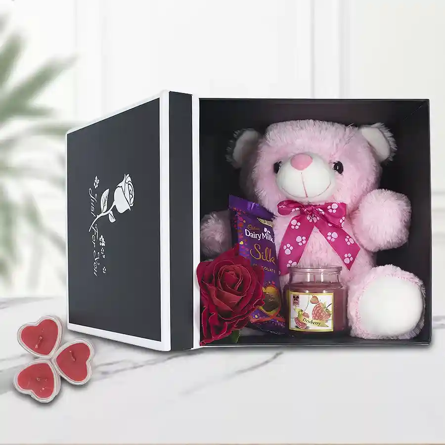Amazing Love Box featuring a teddy bear, Cadbury chocolate, aroma jar candle, heart-shaped candles, and a velvet rose in a premium reusable box.
