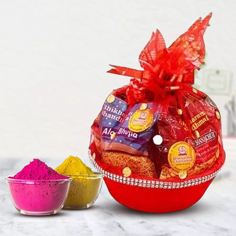 Mesmerizing Munches Gift Basket for Holi featuring namkeen packets, Soan Papdi, Baked Kaju Pista Bites, Cadbury treats, and herbal gulal arranged in a charming basket.