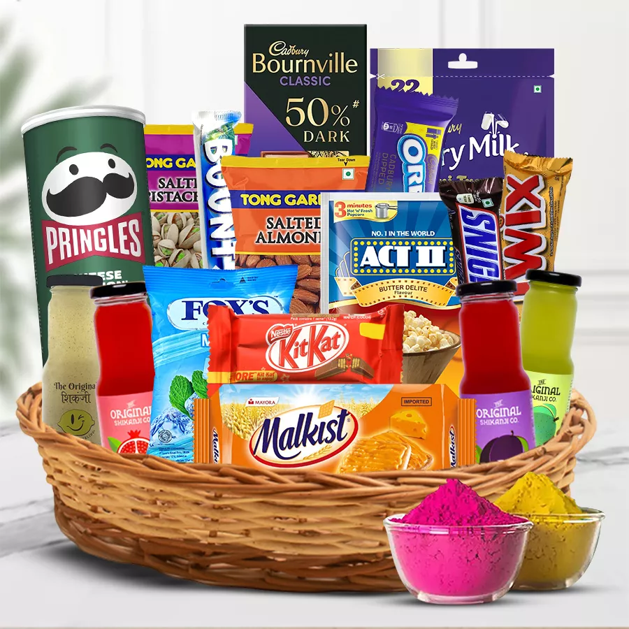 A beautifully arranged basket filled with Tong Garden Roasted Almonds, Pistachios, Cadbury chocolates, Pringles, cheese popcorn, tasty crackers, a Sikanji set, and mixed herbal gulal, celebrating Holi with vibrant colors and gourmet treats.