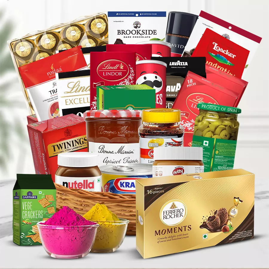 Gourmet gift hamper for Holi featuring cheese, chocolates, snacks, coffee, tea, and a pack of organic gulal in a cane basket