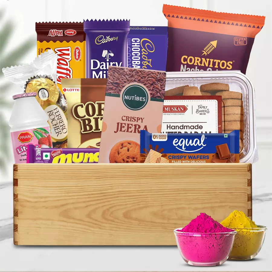 Delightful Goodies Gift Hamper for Holi featuring Ferrero Rocher, Cadbury Dairy Milk, handmade cookies, nacho chips, assorted wafers, Bran Litchi Fruit Drink, and colorful herbal gulal arranged in a wooden stand.