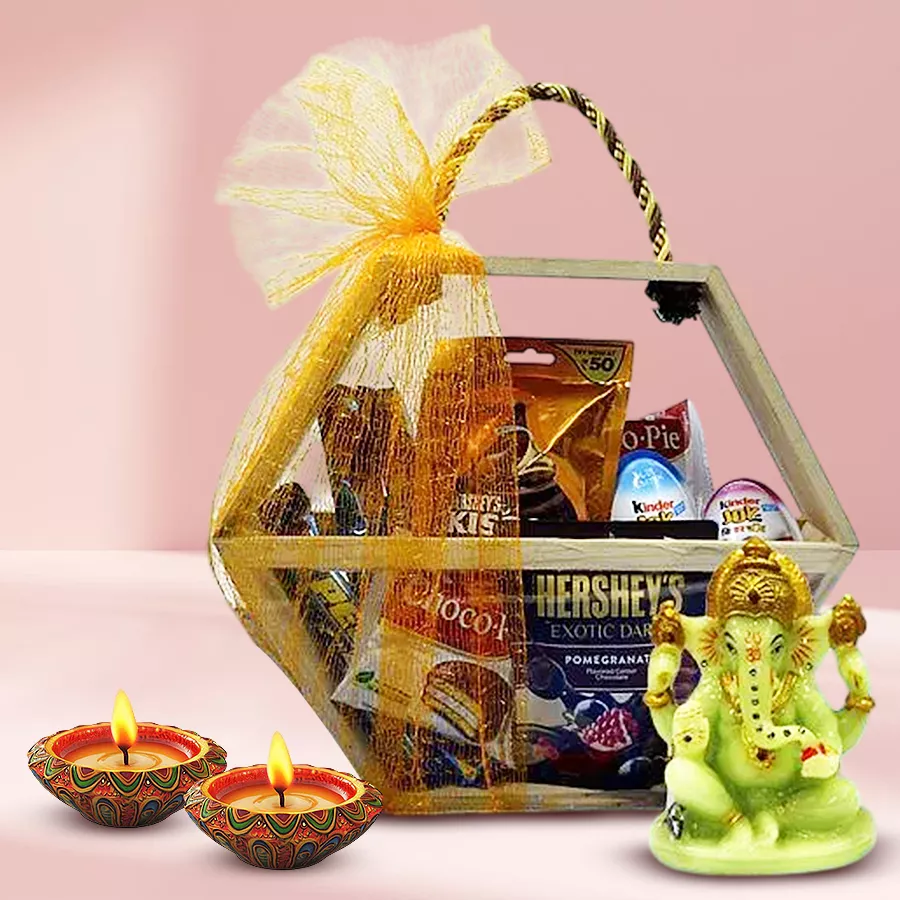 Diwali hamper featuring assorted chocolates, glowing Ganesha idol, and dot mandala diyas in a hexagonal wooden basket