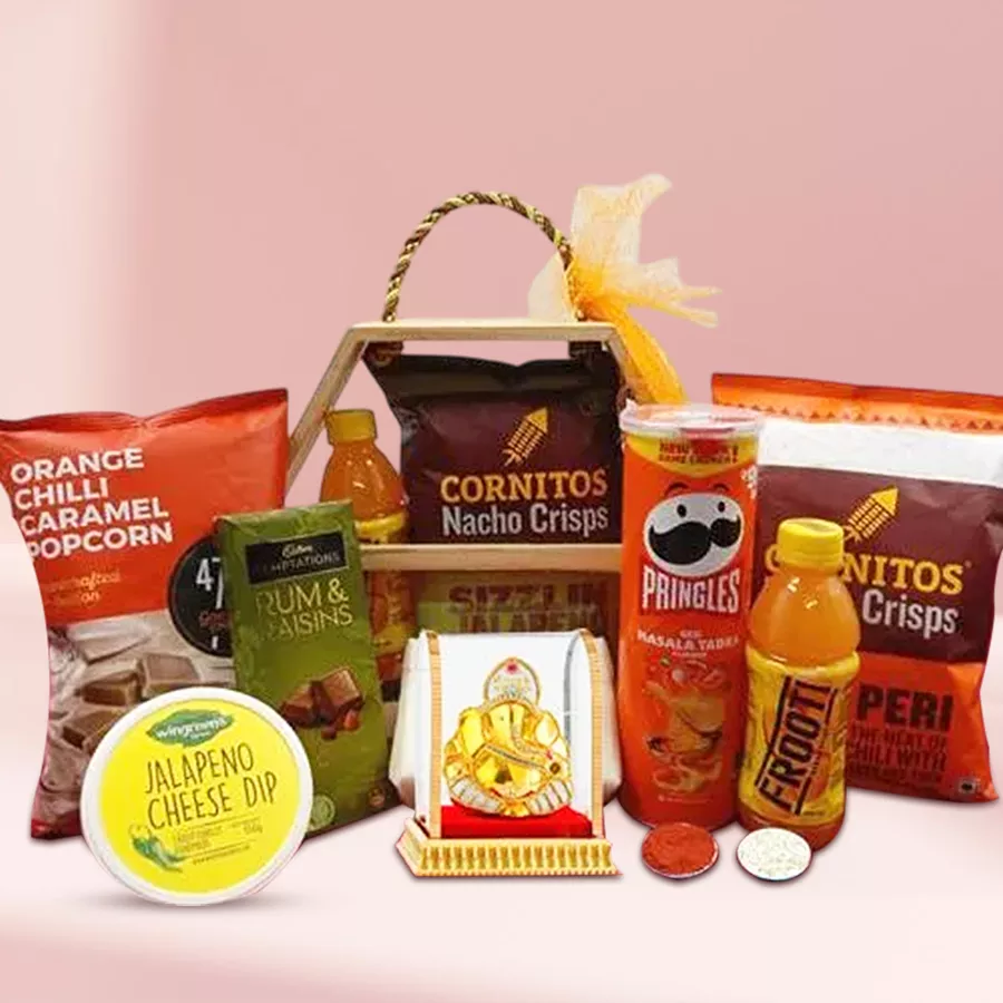 Bountiful Snacks n Chocolate Hamper for Bhai Dooj featuring Pringles, Cornitos nachos, Himalayan caramel popcorn, Cadbury Temptation chocolates, Wingreens cheese dip, Parle snacks, a Vighnesh idol, and a reusable wooden basket, along with Roli Teeka and Chawal.