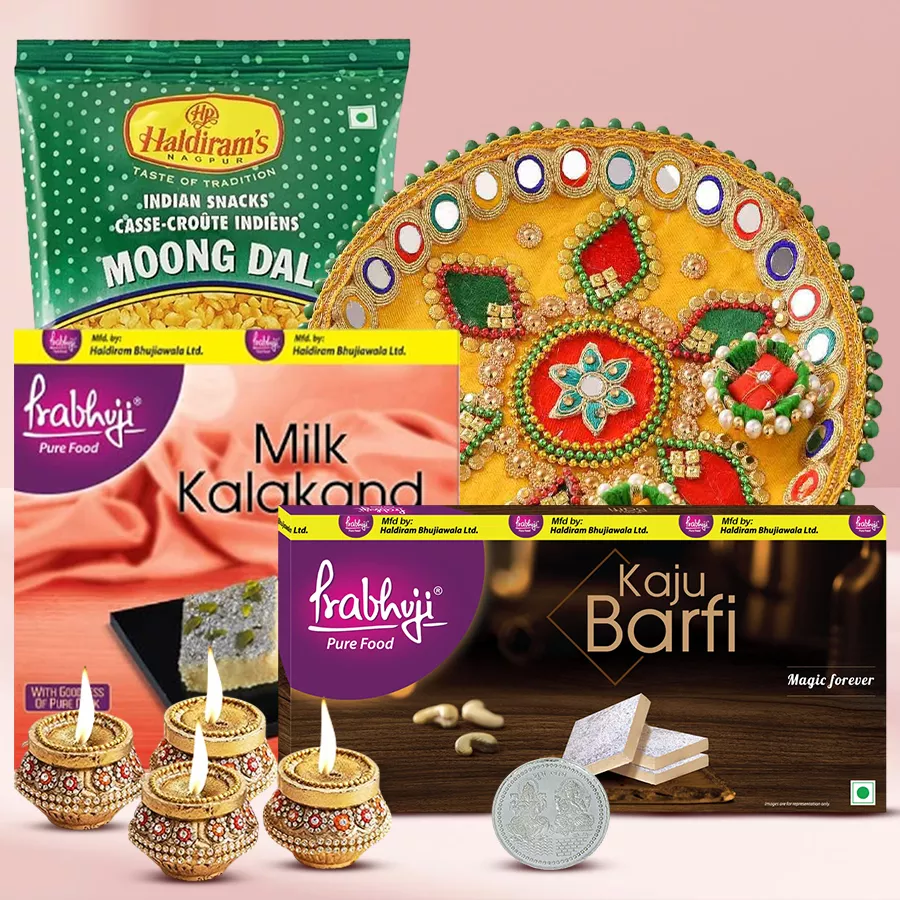 Haldiram Assortments with Devotional Gifts including sweets, terracotta diyas, steel thali, and Laxmi Ganesh silver-plated coin for Diwali celebration