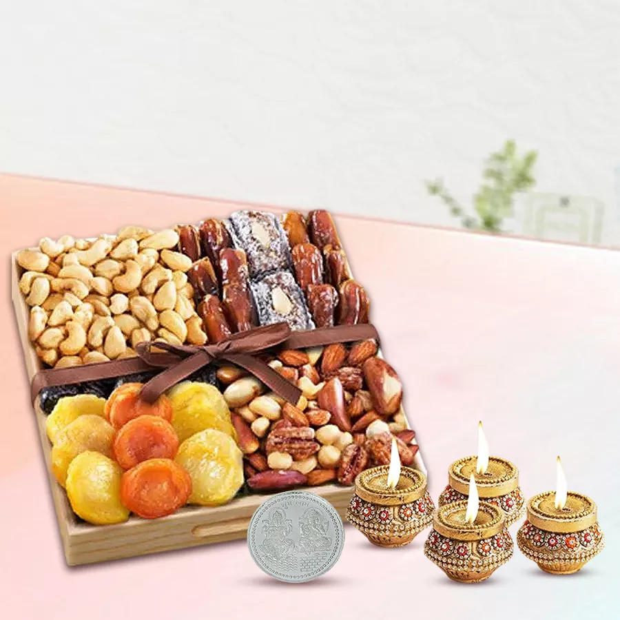Lavish gift hamper featuring dry fruits, a silver-plated Laxmi Ganesh coin, terracotta diyas, and a wooden tray, perfect for Diwali celebrations.