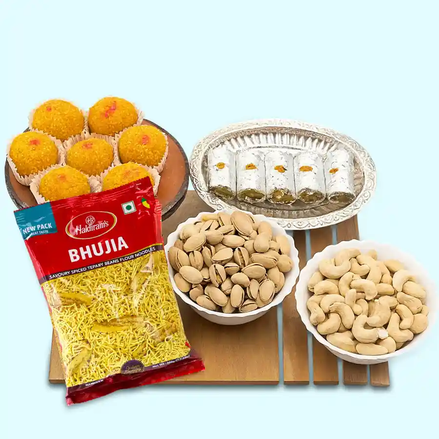 Classy selection of Haldiram sweets and snacks with a decorative silver-plated puja thali and an assortment of dry fruits.