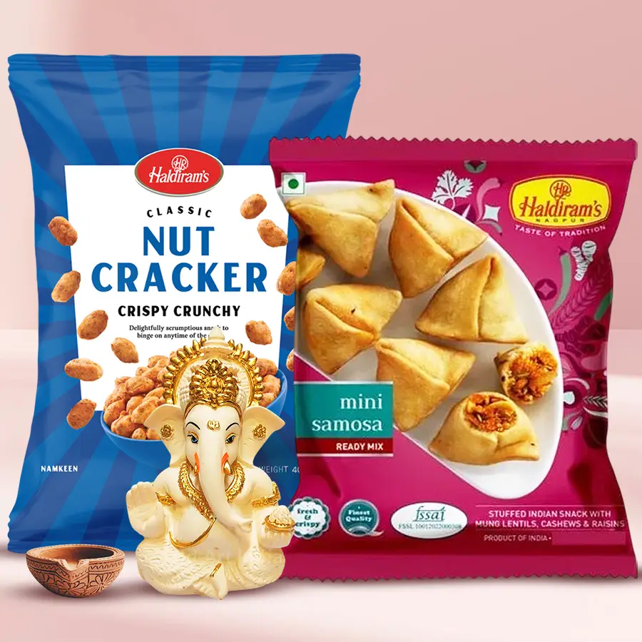 Ceramic Ganesha idol, Haldiram snacks, and terracotta diya arranged on a car dashboard for Diwali decoration.