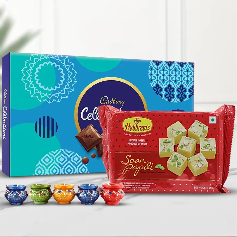 Haldiram Soan Papdi, Cadbury Celebration Chocolates, and Matka Diyas arranged in a festive gift bundle for Diwali celebration