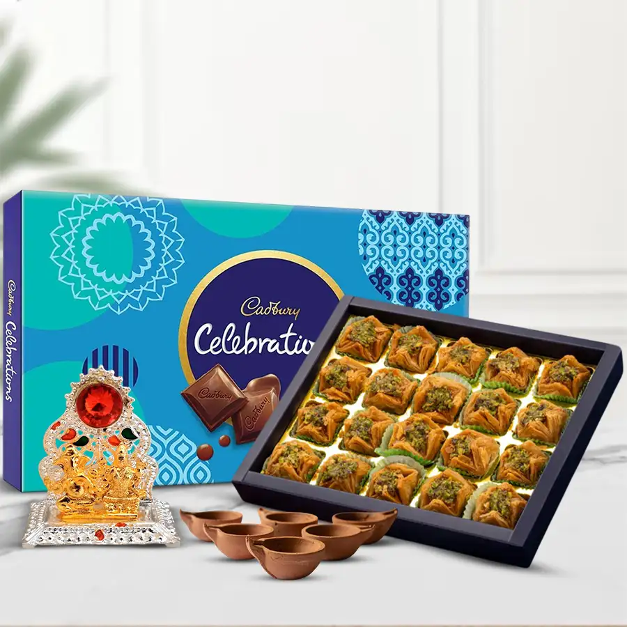 Festive gift arrangement featuring Pyramid Baklawa, Cadbury Celebration chocolates, a Ganesh Laxmi Mandap, and Kuber Mud Diyas for Diwali celebrations.
