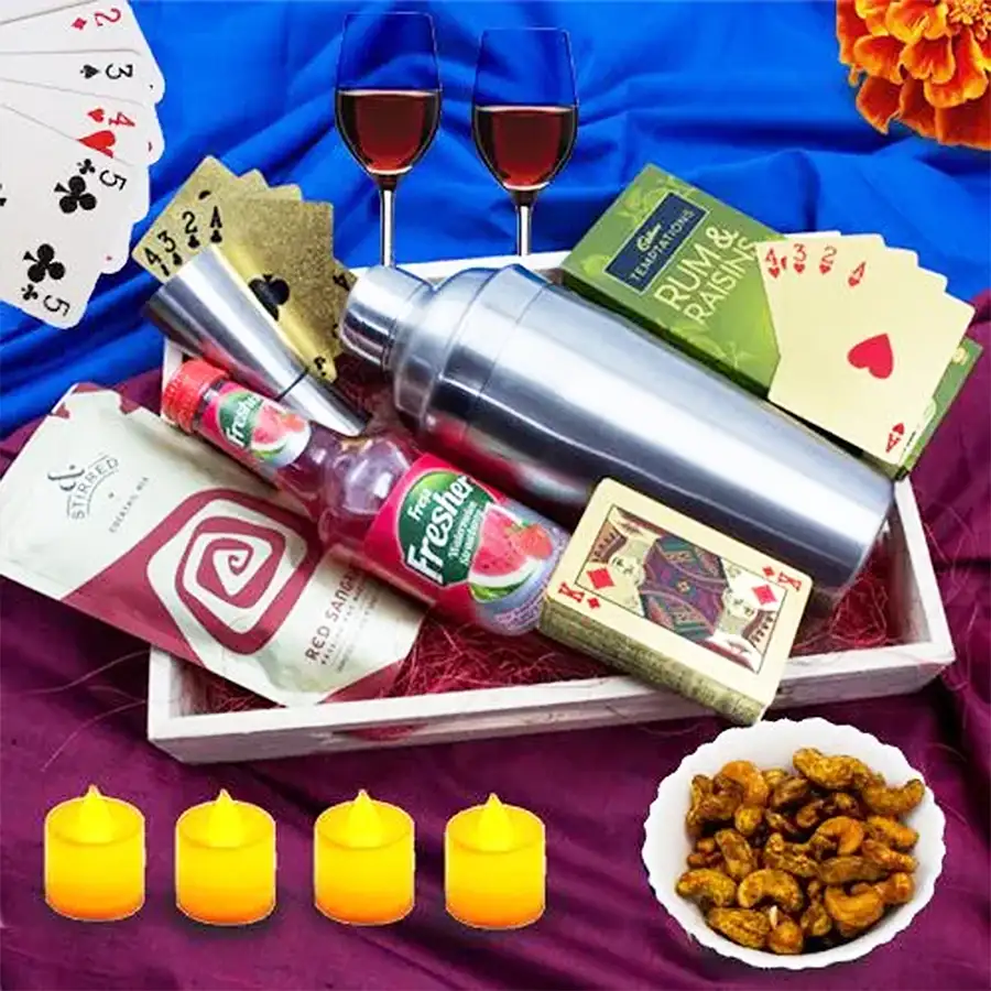 Classy Diwali gift combo featuring Cadbury Temptation chocolates, flavored cashews, shot glasses, cocktail shaker, wine glasses, gold-plated playing cards, and a wooden tray.