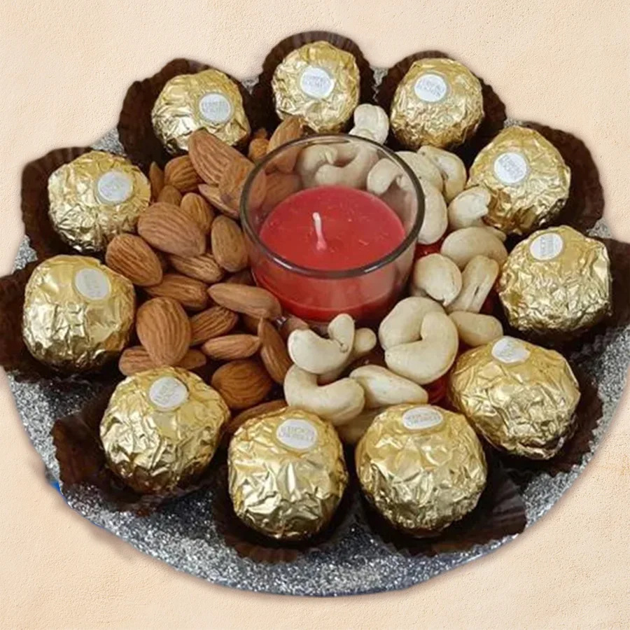 Marvelous Diwali gift pack featuring Ferrero Rocher chocolates, almonds, cashews, an Iris shot glass candle, and a stainless steel thali.
