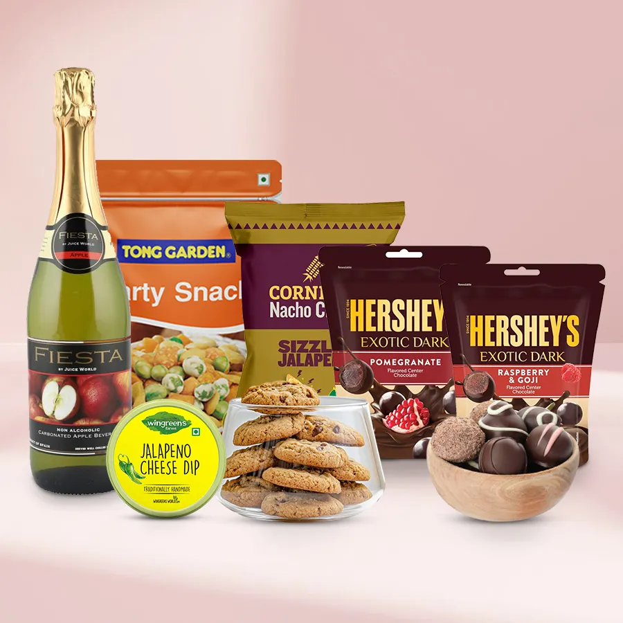 Truly Exotic Gourmet Gift hamper featuring nuts, cookies, chocolate balls, dark chocolates, nachos, cheese dip, and sparkling fruit juice for Christmas.