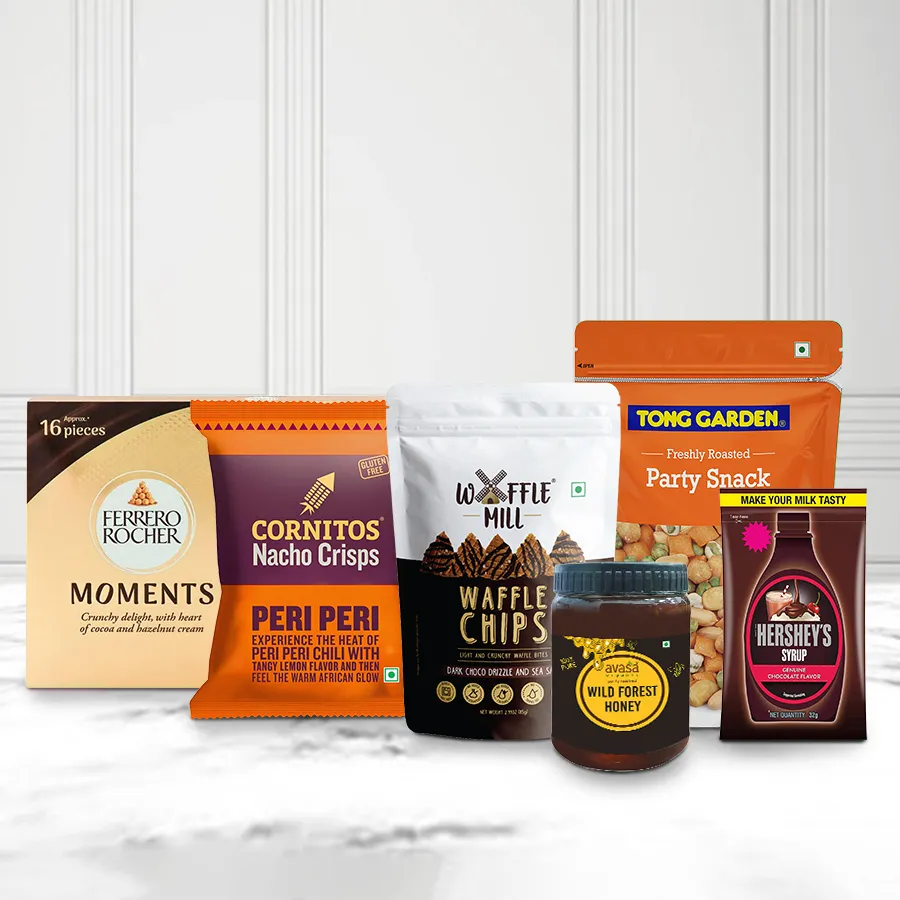 Unique Collection Gourmet Hamper featuring Waffle Chocolate Chips, Cornitos Nachos, Tong Garden Party Mix, Avasa Organic Honey, Hershey’s Chocolate Syrup, and Ferrero Moments, all beautifully arranged for Christmas gifting.