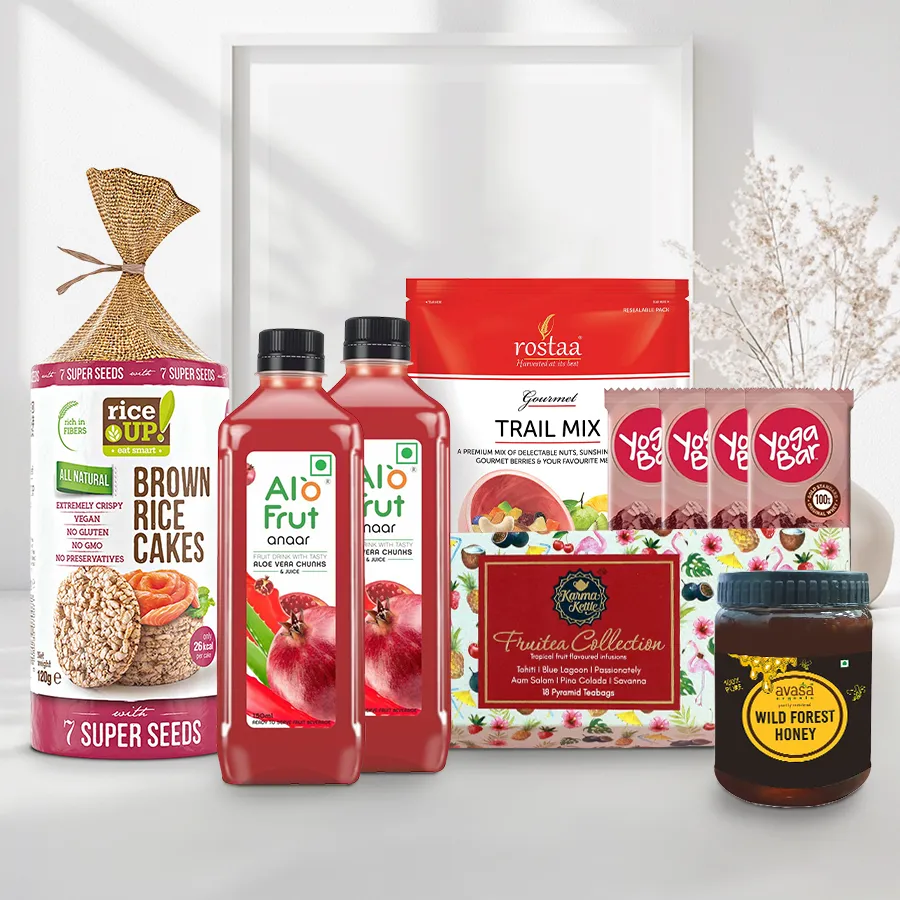 Classic Edible Elegance Gift Hamper featuring assorted treats for Christmas, including trail mix, organic honey, fruit juices, protein bars, a seed cake, and tea collection.