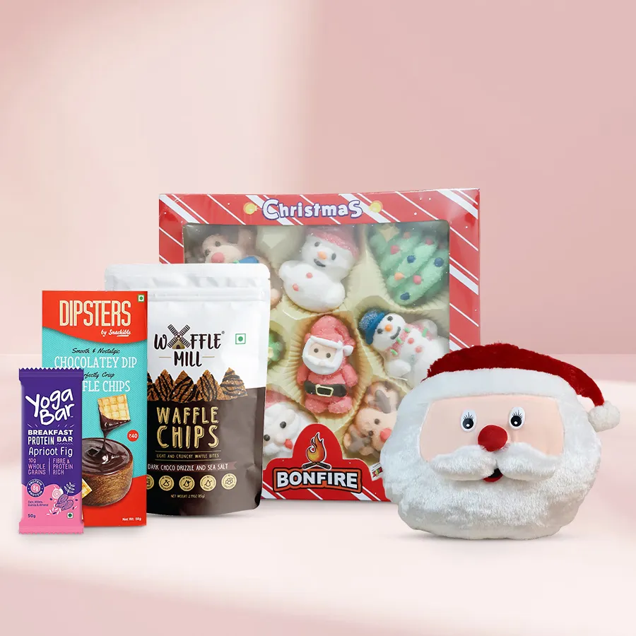 Unique Treasures Chocolate Gift Set featuring a Santa Claus face cushion, marshmallow Christmas box, Snackible Dipsters chocolate dip with waffle chips, Waffle Mill dark chocolate drizzle with sea salt, and a yoga protein bar.