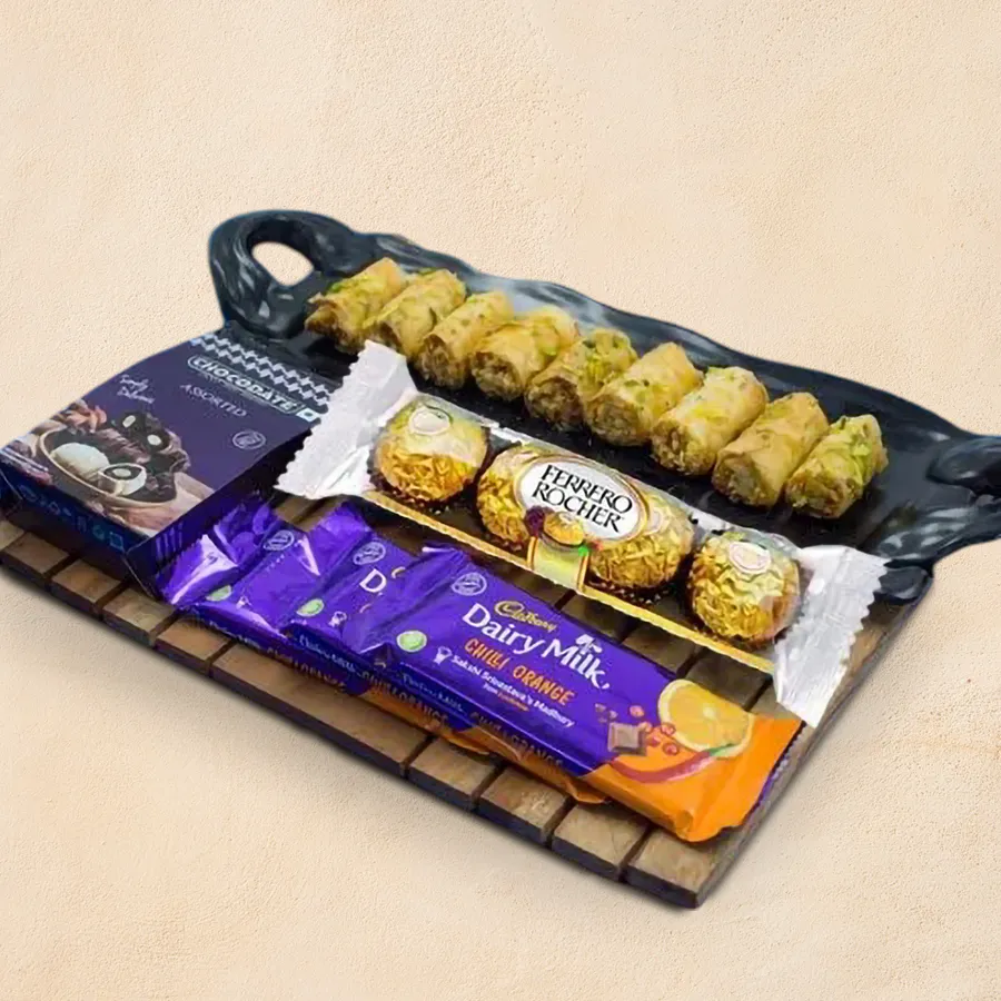 Ambrosial Gift of Roll Baklava and Chocolate Assortments including baklava, Cadbury Dairy Milk Chilli Oranges, Ferrero Rocher chocolates, and a stylish chocolate box
