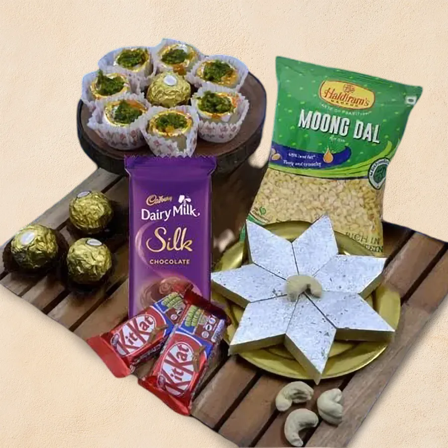 Delicious Haldirams sweets and snacks hamper featuring Kaju Pista Flower, Kaju Barfi, Cadbury Dairy Milk Silk, Ferrero Rocher, Nestle KitKat, and Haldirams Moong Dal.