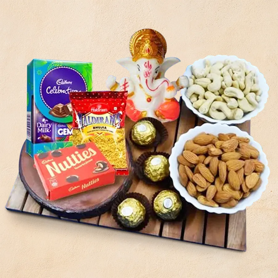 Classic marble Ganpati idol with assorted dry fruits, snacks, and chocolates in a festive gift hamper