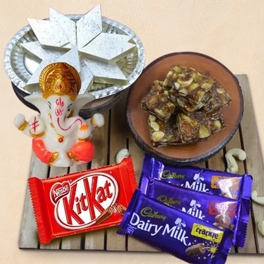 Marble Ganesha idol surrounded by an assortment of Cadbury chocolates and Haldiram sweets