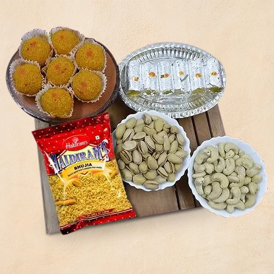 Luscious Haldiram Sweets, Snacks, and Assorted Dry Fruits Combo including Kesar Laddu, Kaju Roll, pistachios, cashews, and Haldiram Bhujia in an attractive arrangement.