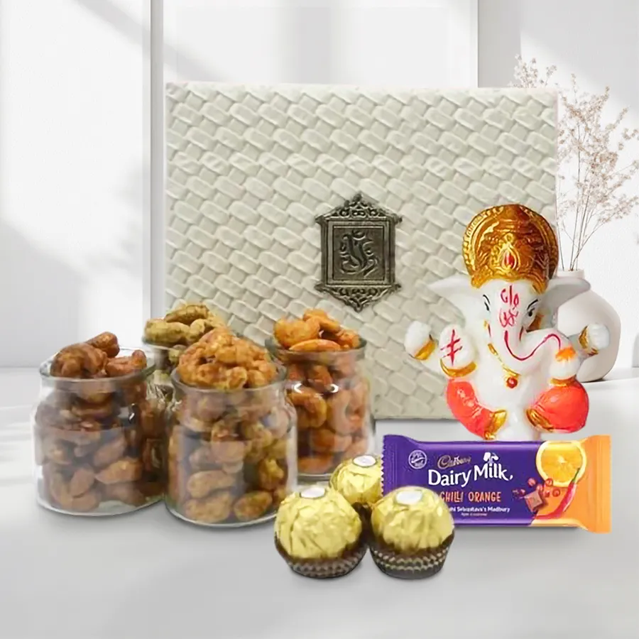 Marble Ganpati idol surrounded by flavored cashews and chocolates in an elegant gift box