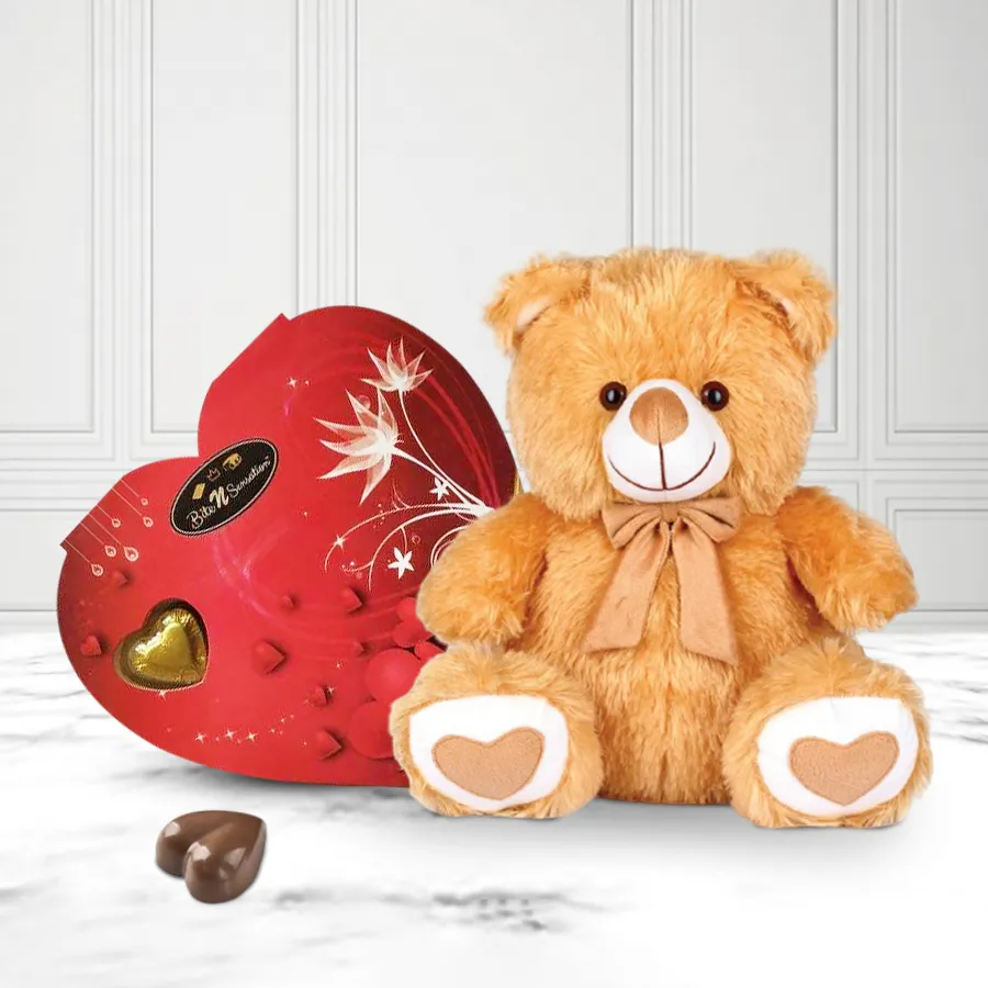 Heart-shaped handmade chocolates in a decorative box with a cute teddy bear, perfect for Valentine's Day gift.