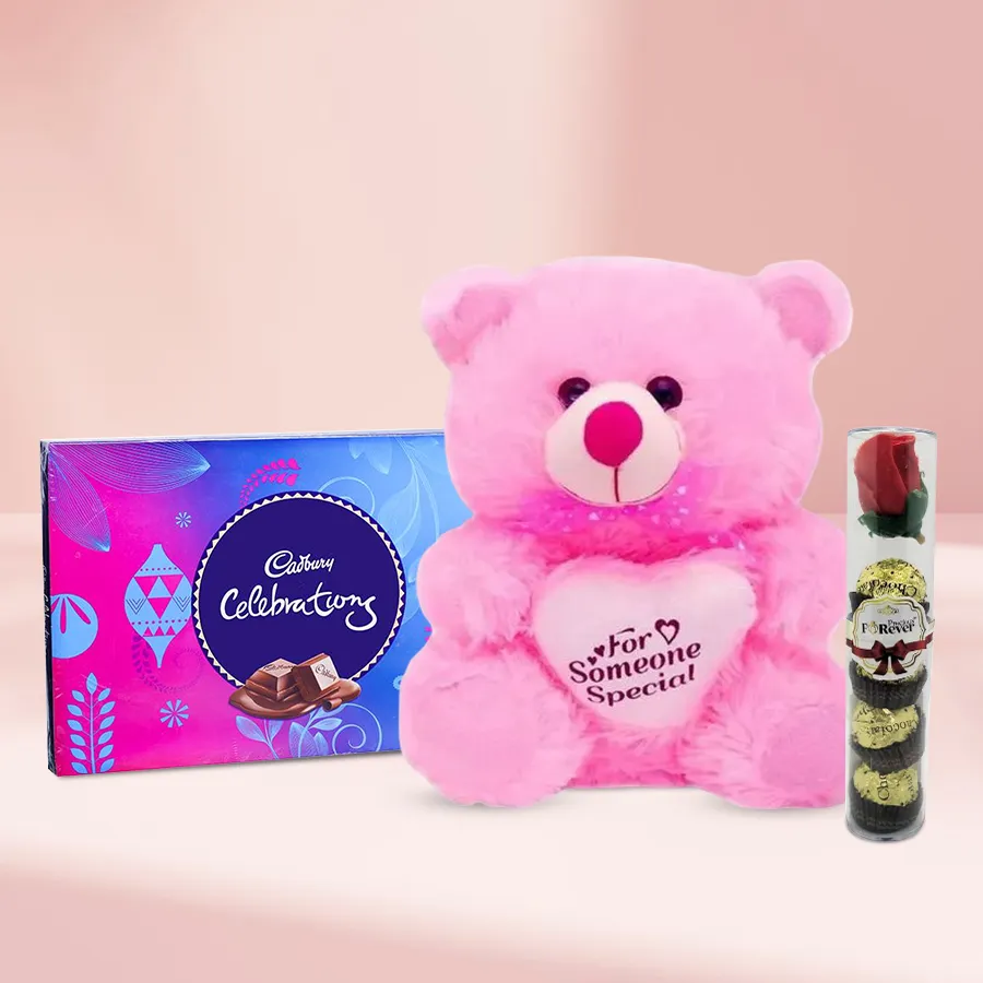 Heart-shaped teddy bear with handmade chocolates and a pack of Cadbury Celebrations in a romantic setting.