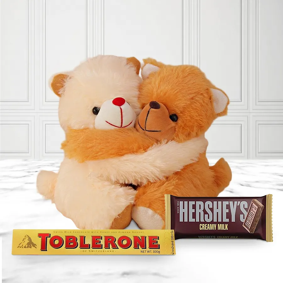 Cute hugging teddy bears with a pouch of Toblerone milk chocolate and a Hershey's milk chocolate bar.