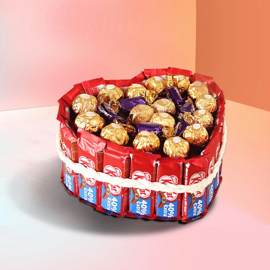 Heart-shaped bouquet made of 20 Nestle KitKats, 16 Ferrero Rocher, and Cadbury Choclairs Gold candies, tied with white yarn.