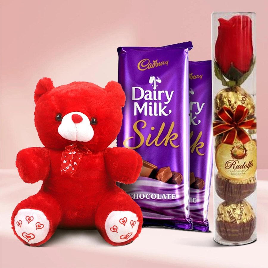 Delectable gift bundle featuring Cadbury Dairy Milk Silk chocolates, Rudolfo chocolates, colorful roses, and a cuddly teddy bear for Valentine's Day.