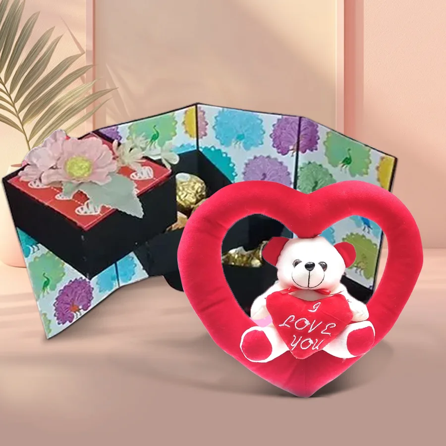 Four-layer stepper box of chocolates with Ferrero Rocher, KitKats, and Hershey’s Kisses, featuring a teddy bear inside a heart on top
