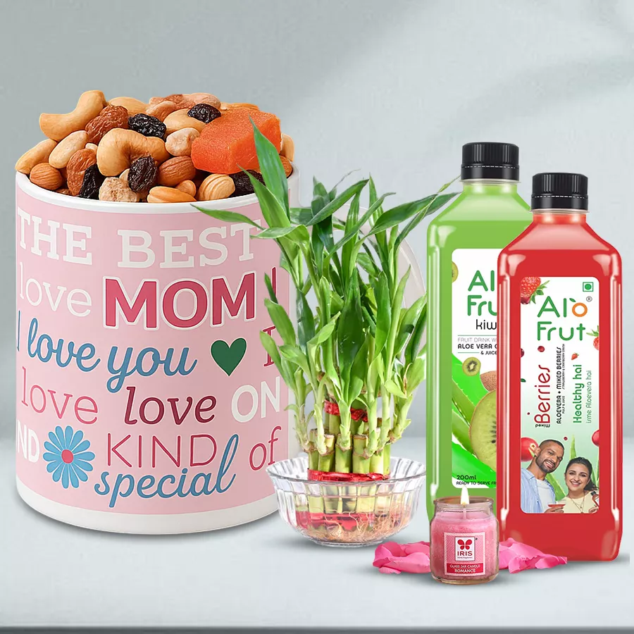 Personalized coffee mug surrounded by almonds, Alo-Fruit juice bottles, a lucky bamboo plant, and an aroma candle in a shot glass, all presented as a Mother's Day gift set.
