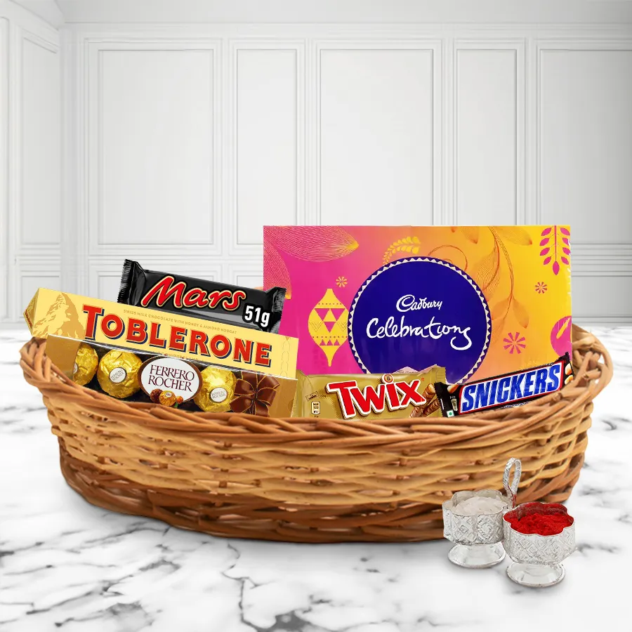 Delectable Chocolates Gift Hamper for Bhai Dooj featuring Toblerone, Ferrero Rocher, Snickers, Twix, Mars bar, Cadbury Celebration, Roli, Tika, and Chawal in a charming basket