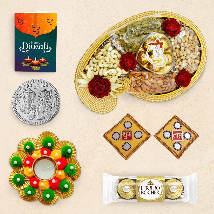 Diwali gift hamper featuring a Pearl Chopra Tray with assorted nuts, chocolates, a designer diya, Shubh Labh wall stickers, a silver-plated coin, and a Diwali greeting card.