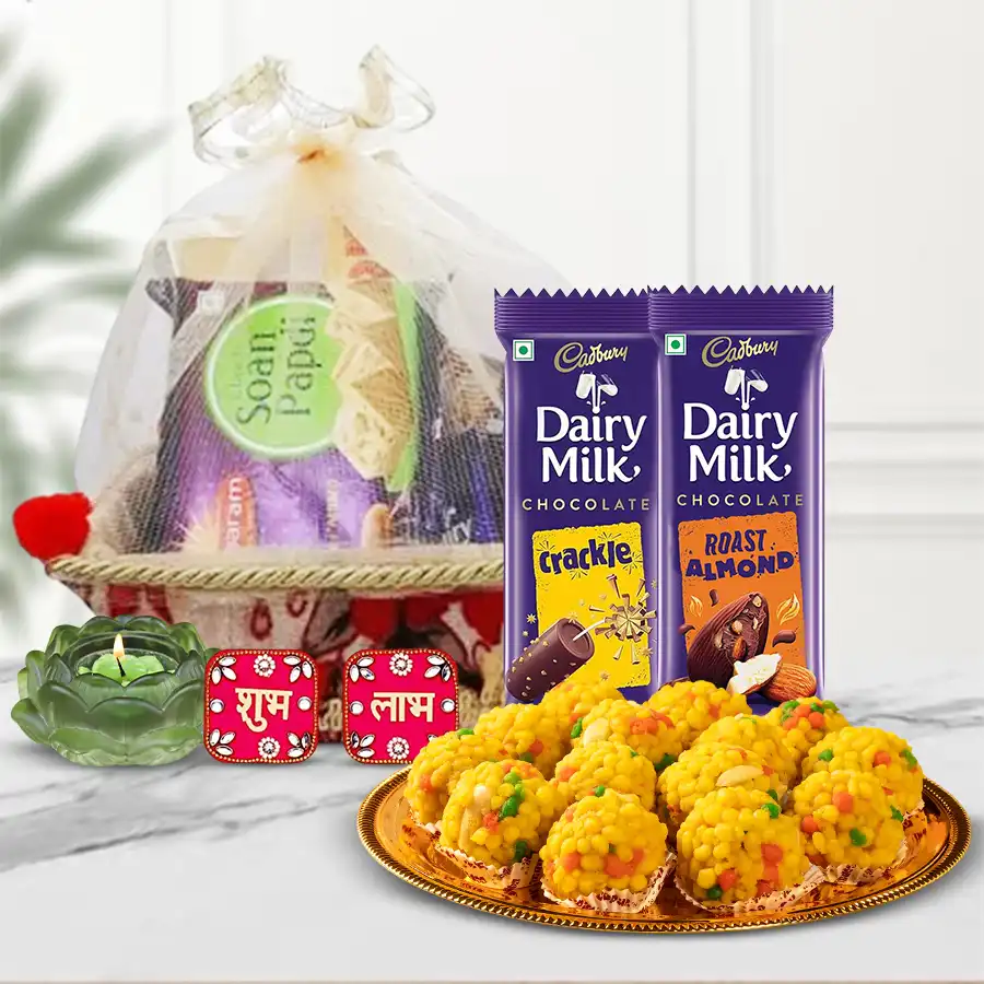 Divine Lotus Candle-Holder and Sweets Hamper featuring Boondi Laddoos, Cadbury Crackle and Roast Almond chocolates, a Lotus Tea Light Candle Holder, a Shubh Labh wall sticker, and a beautifully decorated gift basket.