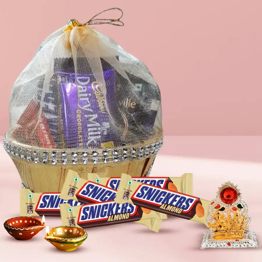 Chocolaty Bash gift hamper for Diwali featuring Snickers Almond bars, decorated wax diyas, a Ganesh Laxmi mandap, and a decorative basket.