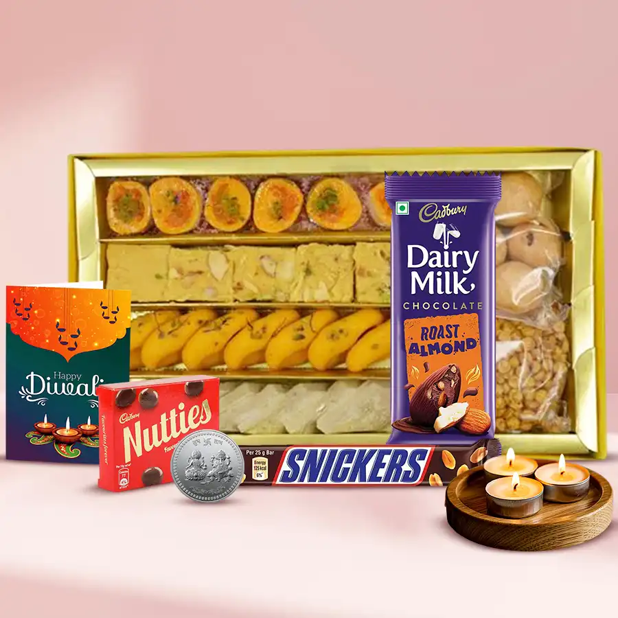 Diwali Sweets Gala Gift Hamper filled with Kaju Katli, Soan Papdi, Cadbury chocolates, Snickers, tea light candles, a silver Ganesh Lakshmi coin, and a festive card.