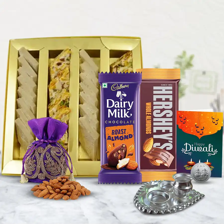 Diwali gift hamper featuring sweet treats like dry fruit barfi, kaju barfi, chocolate bars, almond potli, Ganesh Laxmi coin, and decorative Pooja thali with a Diwali card.