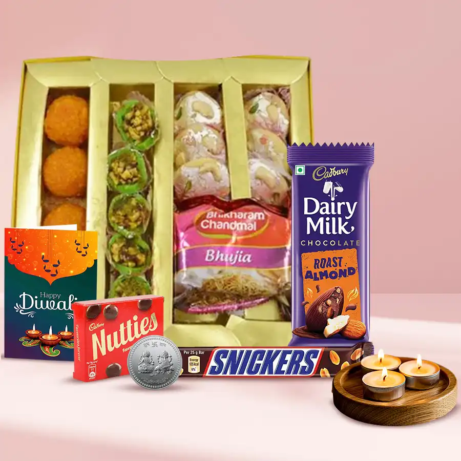 Sweet Desire Diwali Gift Hamper featuring Mawa Tikiya, Kesar Laddoos, assorted snacks, Cadbury chocolates, Snickers, tea light candles, a silver Ganesh-Laxmi coin, and a Diwali card.