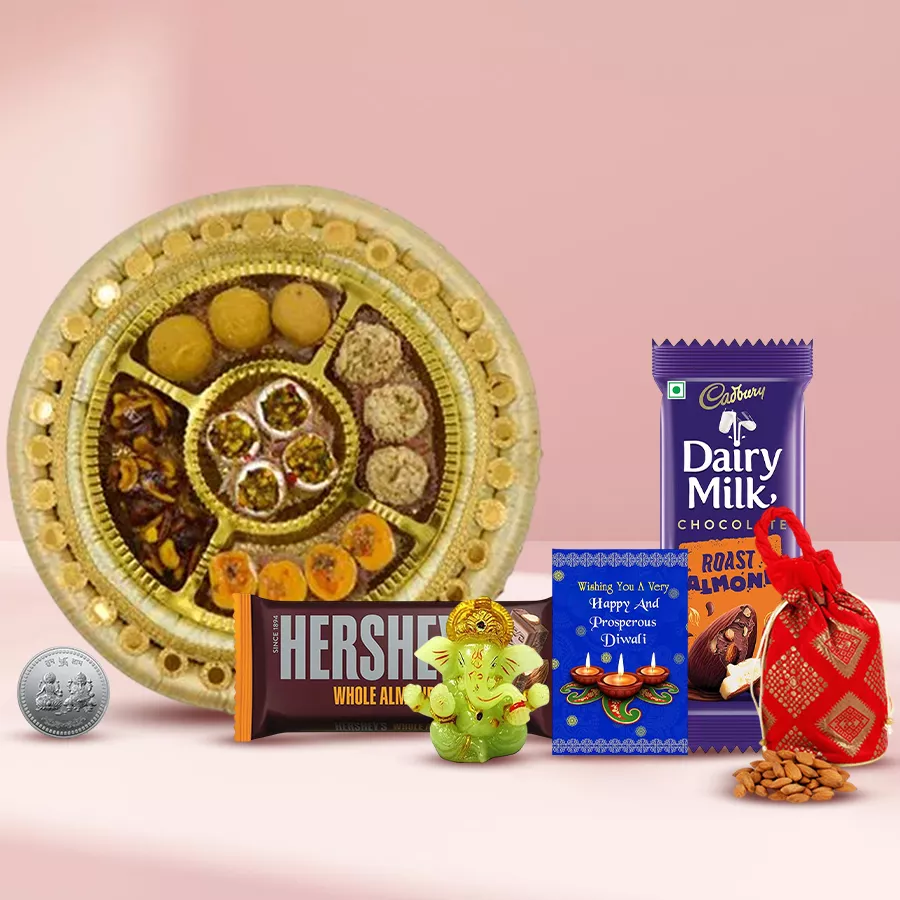 Traditional Delight Gift Hamper filled with mixed sweets, chocolate bars, a Silver Plated Ganesh Laxmi Coin, a Ganesh idol, an almond potli, and a Diwali card.