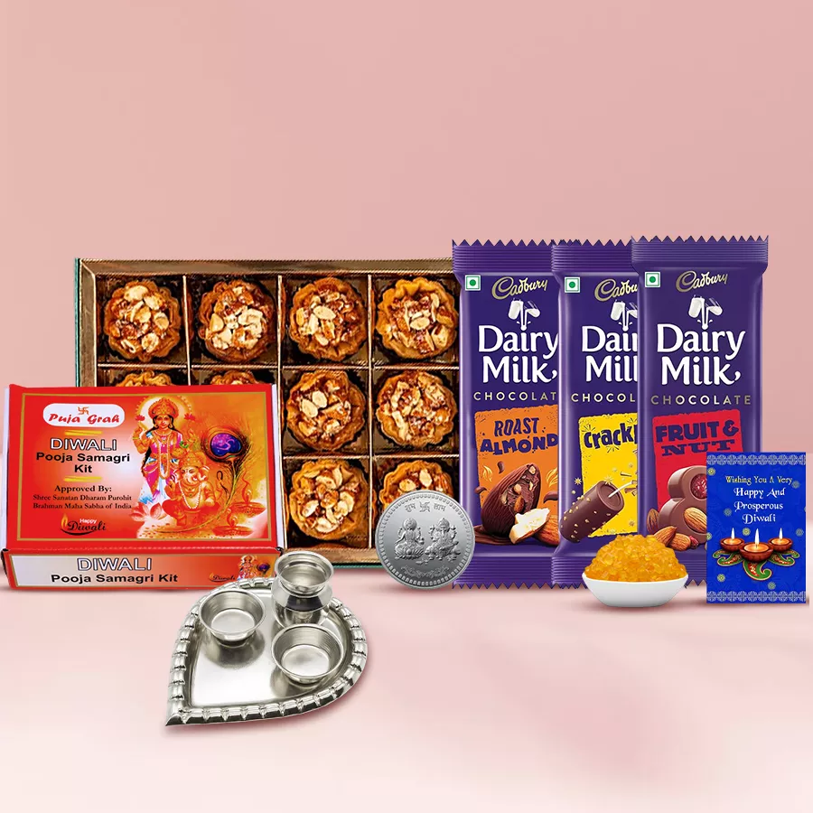 Blithesome Almond Tart Baklava and Cadbury Delight hamper featuring almond tart baklava, Cadbury Dairy Milk bars, silver-plated pooja thali, Ganesh Lakshmi coins, Kesaria Misri, pooja samagri, and a Diwali card.