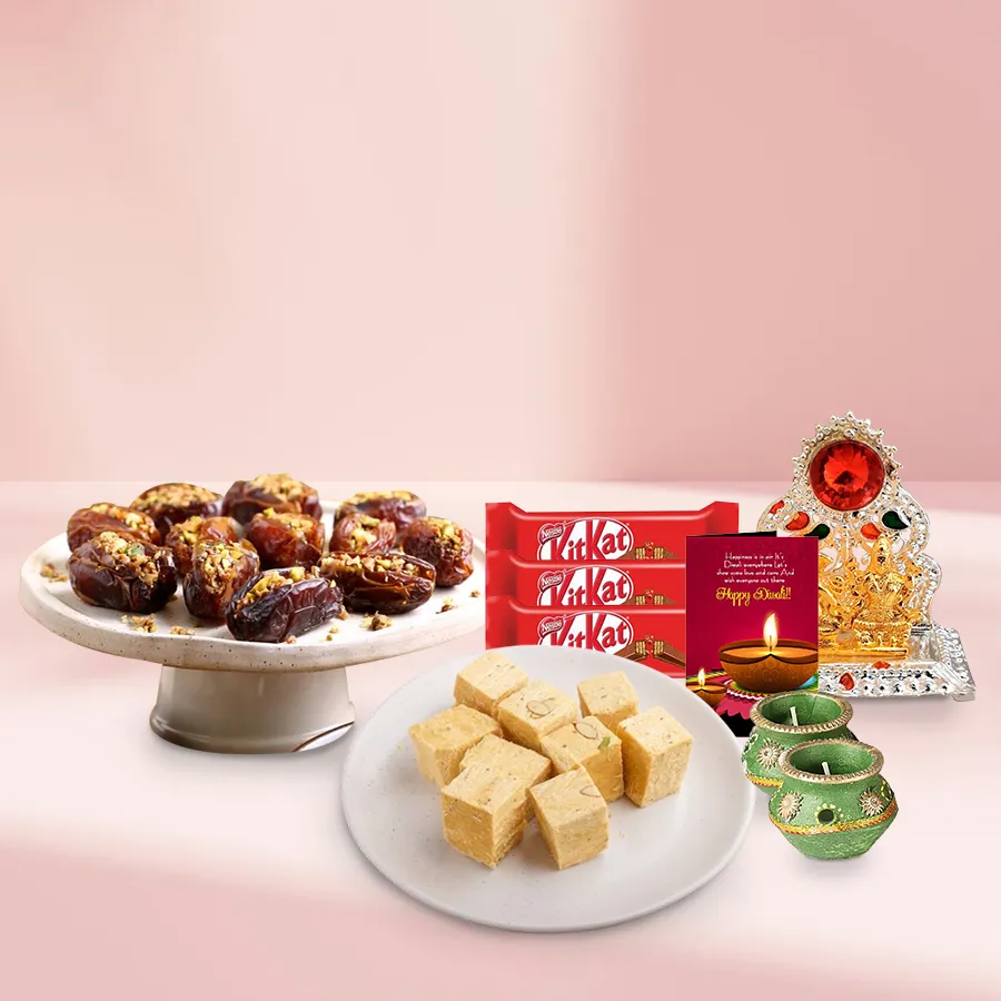 Dates Baklava Delight gift basket featuring 250g Dates Baklava, 200g Soan Papdi, Nestle KitKat Chocolate Fingers, decorative wax diyas, Ganesh-Laxmi mandap, and a Diwali card.