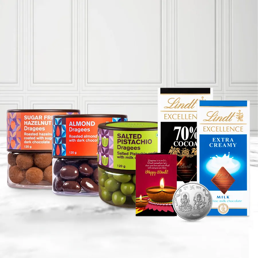 Gift basket featuring Winsome Dragee and Lindt Chocolates, including Almond, Pistachio, and Sugar-Free Hazelnut Dragees, Lindt Excellence Dark and Extra Creamy chocolates, a silver-plated Ganesh Laxmi coin, and a personalized Diwali card.